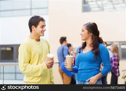friendship, people, drinks and education concept - group of smiling students with paper coffee cups outdoors
