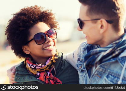 friendship, relations, tourism, travel and people concept - group of happy teenage friends or couple in sunglasses talking outdoors