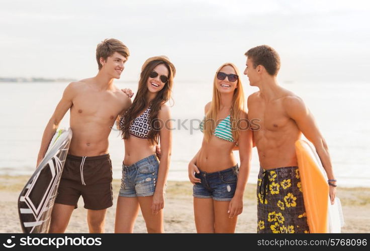 friendship, sea, summer vacation, water sport and people concept - group of smiling friends wearing swimwear and sunglasses with surfboards on beach