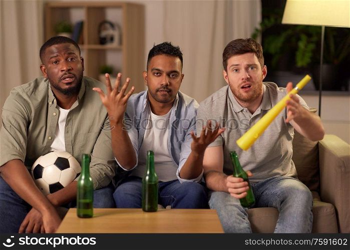 friendship, sports and entertainment concept - disappointed male friends or football fans with soccer ball, beer and vuvuzela at home. sad male friends or soccer fans with beer at home