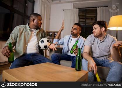 friendship, sports and entertainment concept - disappointed male friends with soccer ball and vuvuzela watching football game at home. sad friends with ball and vuvuzela watching soccer