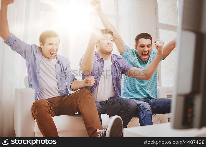 friendship, sports and entertainment concept - happy male friends supporting football team at home