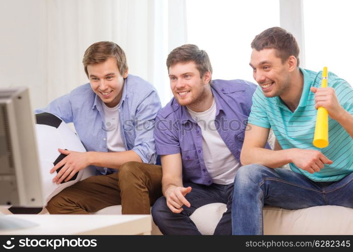 friendship, sports and entertainment concept - happy male friends with football and vuvuzela supporting football team at home