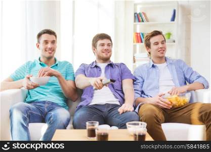 friendship, sports and entertainment concept - happy male friends with snacks watching tv at home