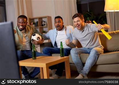 friendship, sports and entertainment concept - happy male friends with soccer ball and vuvuzela supporting football team at home. friends with ball and vuvuzela watching soccer