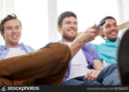 friendship, sports, people and entertainment concept - happy male friends with remote control watching tv at home