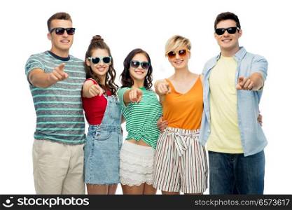 friendship, summer and people concept - group of happy smiling friends in sunglasses hugging over white background pointing at you. friends in sunglasses pointing at you