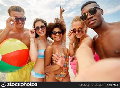 friendship, summer holidays and people concept - group of happy friends taking selfie on beach. happy friends taking selfie on summer beach