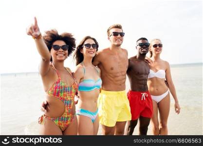 friendship, summer holidays and people concept - happy friends hugging on beach. happy friends hugging on summer beach