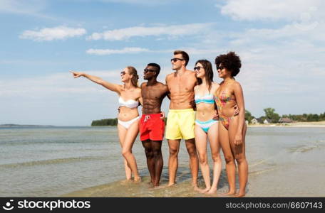 friendship, summer holidays and people concept - happy friends hugging on beach. happy friends hugging on summer beach