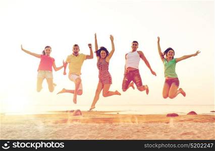 friendship, summer vacation, holidays, party and people concept - group of smiling friends dancing and jumping on beach. smiling friends dancing and jumping on beach
