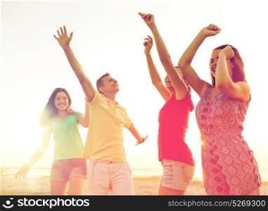friendship, summer vacation, holidays, party and people concept - group of smiling friends dancing on beach. smiling friends dancing on summer beach