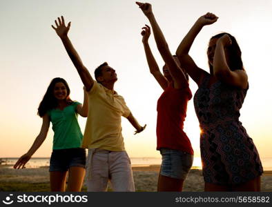 friendship, summer vacation, holidays, party and people concept - group of smiling friends dancing on beach