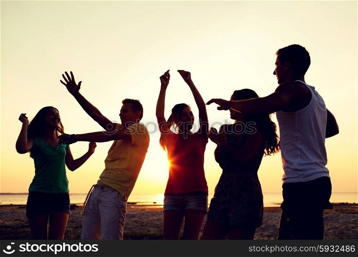 friendship, summer vacation, holidays, party and people concept - group of smiling friends dancing on beach