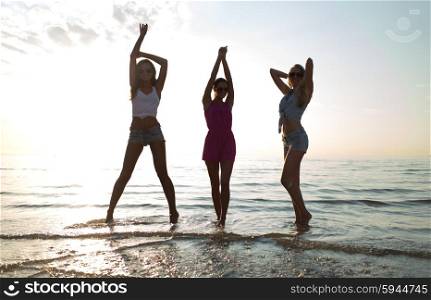 friendship, summer vacation, party, happiness and people concept - group of happy female friends dancing on beach