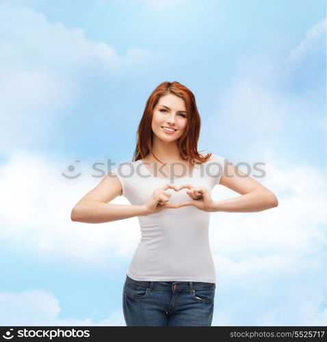 friendship, t-shirt design and happy people concept - smiling girl in white blank t-shirts showing heart with hands