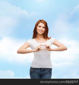 friendship, t-shirt design and happy people concept - smiling girl in white blank t-shirts showing heart with hands