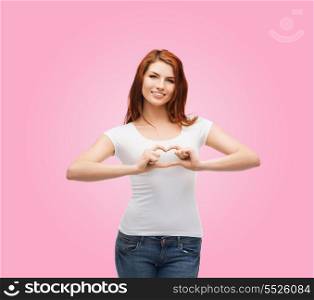 friendship, t-shirt design and happy people concept - smiling girl in white blank t-shirts showing heart with hands