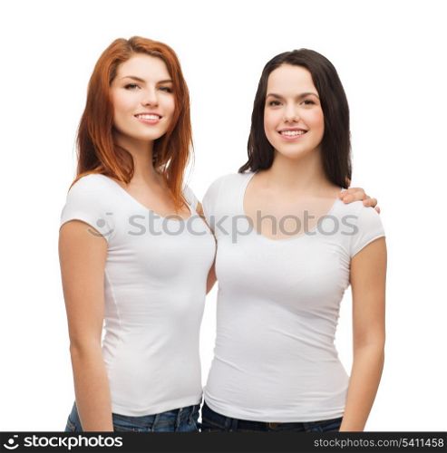 friendship, t-shirt designe and happy people concept - two laughing girls in white blank t-shirts hugging