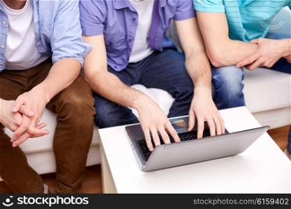 friendship, technology and people concept - close up of male friends with laptop computer at home