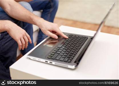 friendship, technology and people concept - close up of male hands with laptop computer at home