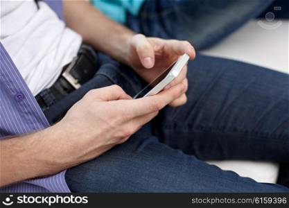 friendship, technology and people concept - close up of male hands with smartphones texting at home