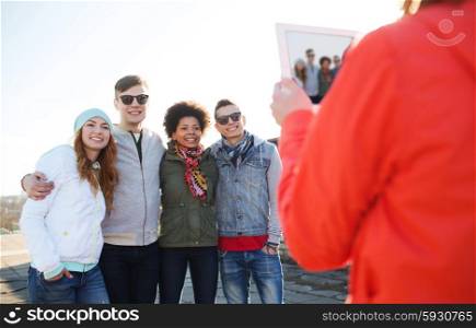 friendship, technology and people concept - group of happy teenage friends in sunglasses with tablet pc computer photographing outdoors