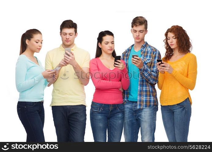 friendship, technology and people concept - group of serious teenagers with smartphones