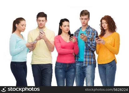 friendship, technology and people concept - group of serious teenagers with smartphones