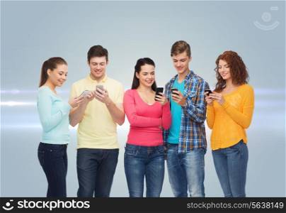 friendship, technology and people concept - group of smiling teenagers with smartphones over gray background with laser light