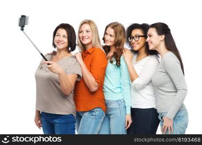 friendship, technology, body positive and people concept - group of happy different size women in casual clothes taking picture with smartphoone on selfie stick