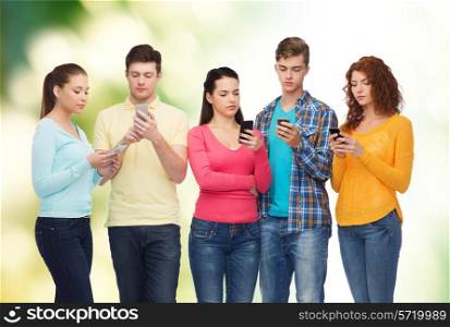 friendship, technology, ecology and people concept - group of serious teenagers with smartphones over natural background