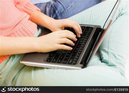 friendship, technology, people and internet concept - close up of young women or teenage girls with laptop computer at home