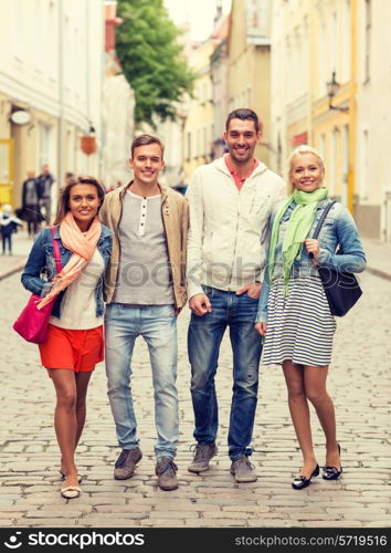 friendship, travel and vacation concept - group of smiling friends walking in the city