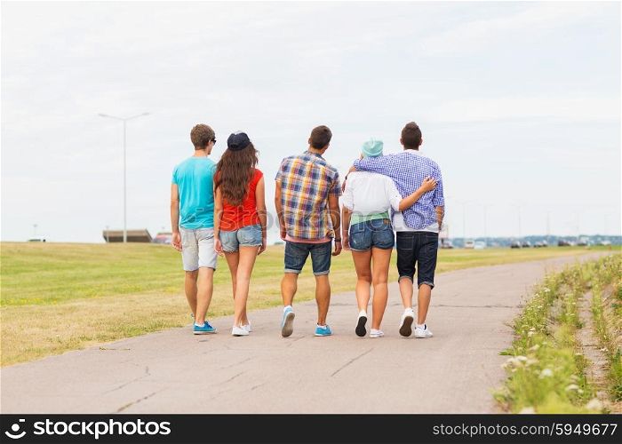 friendship, travel, tourism, summer vacation and people concept - close up of teenage friends walking outdoors from back
