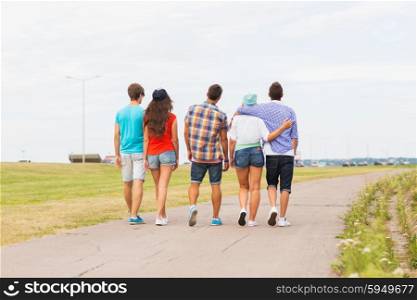 friendship, travel, tourism, summer vacation and people concept - close up of teenage friends walking outdoors from back