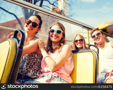 friendship, travel, vacation, summer and people concept - group of smiling friends traveling by tour bus