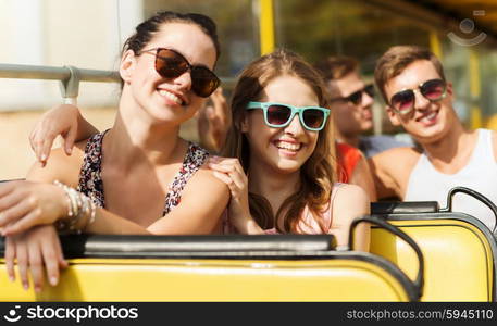 friendship, travel, vacation, summer and people concept - group of smiling teenage friends in sunglasses traveling by tour bus