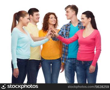 friendship, youth and people concept - group of smiling teenagers making high five