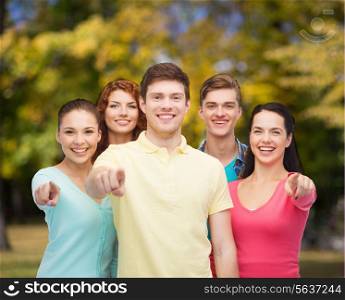 friendship, youth and people concept - group of smiling teenagers pointing fingers on you