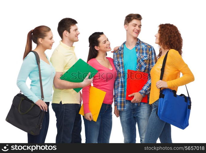 friendship, youth, education and people concept - group of smiling teenagers with folders and school bags