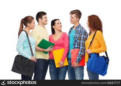 friendship, youth, education and people concept - group of smiling teenagers with folders and school bags