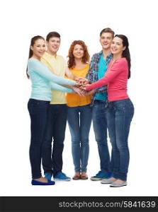 friendship, youth, gesture and people - group of smiling teenagers with hands on top of each other