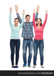 friendship, youth, greeting and people - group of smiling teenagers with raised hands