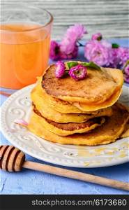 fritter pancakes with light dishes and glass of juice. pancakes with pumpkin