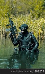 Frogman with complete diving gear and weapons in the water. Frogman with weapons