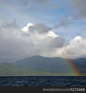 from a boat the rainbow from ocean and island in background