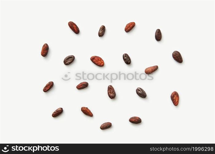 From above pile of scattered peeled aromatic cocoa beans of Theobroma cacao tree on white background. Scattered raw beans of cocoa