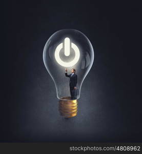 From inside of idea. Man holding luminous idea inside light bulb