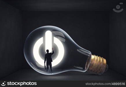 From inside of idea. Man holding luminous idea inside light bulb